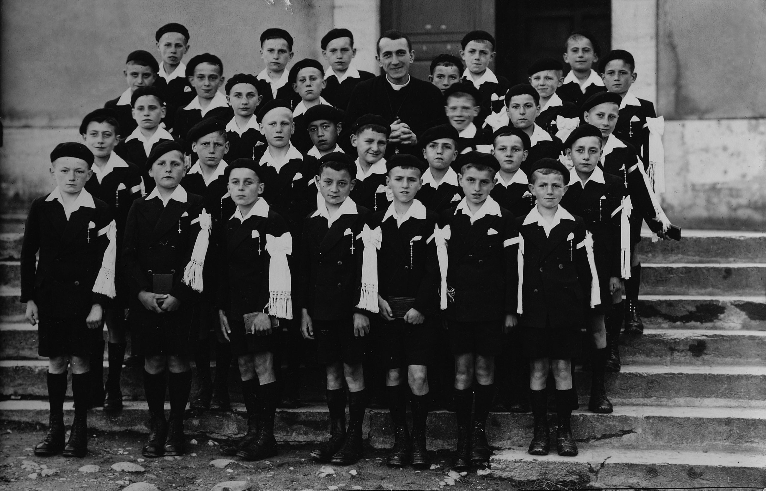 L’abbé Grouès, aumônier au foyer départemental de garçons à la Côte-Saint-André (Isère), avec les orphelins de l’Assistance Publique, le jour de leur communion solennelle, 1942. ©Emmaüs International